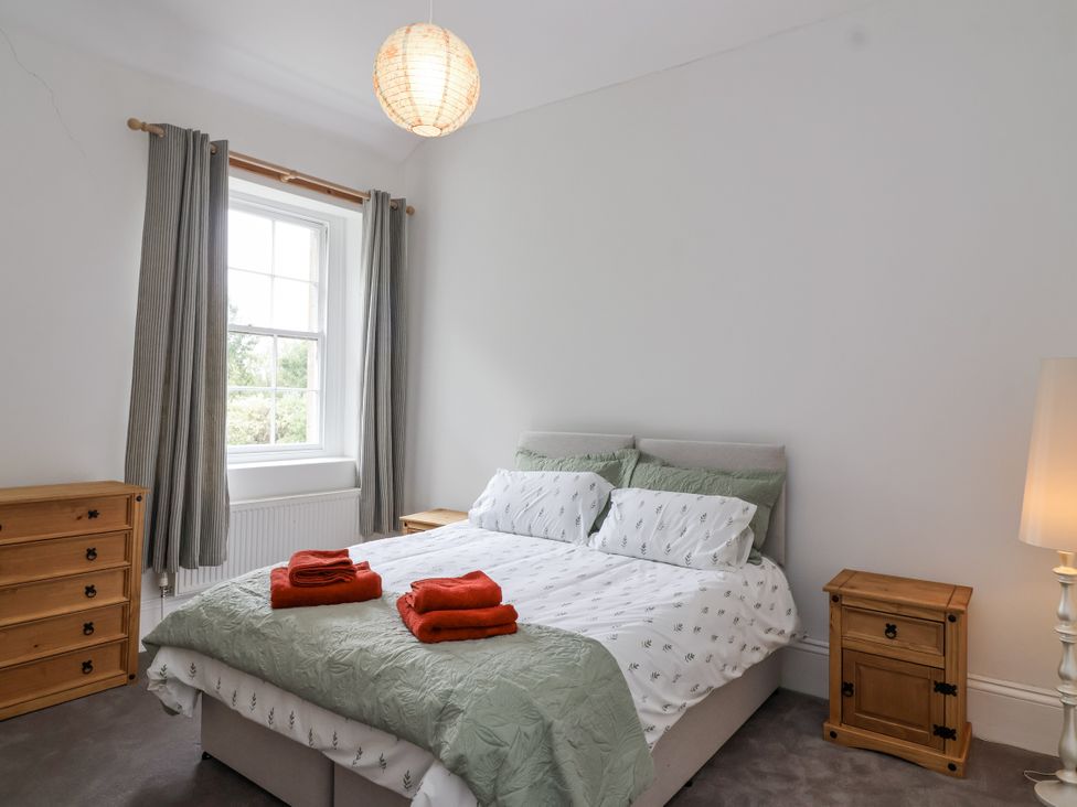 A bedroom with a bed and dresser at The Cottage in Clevedon