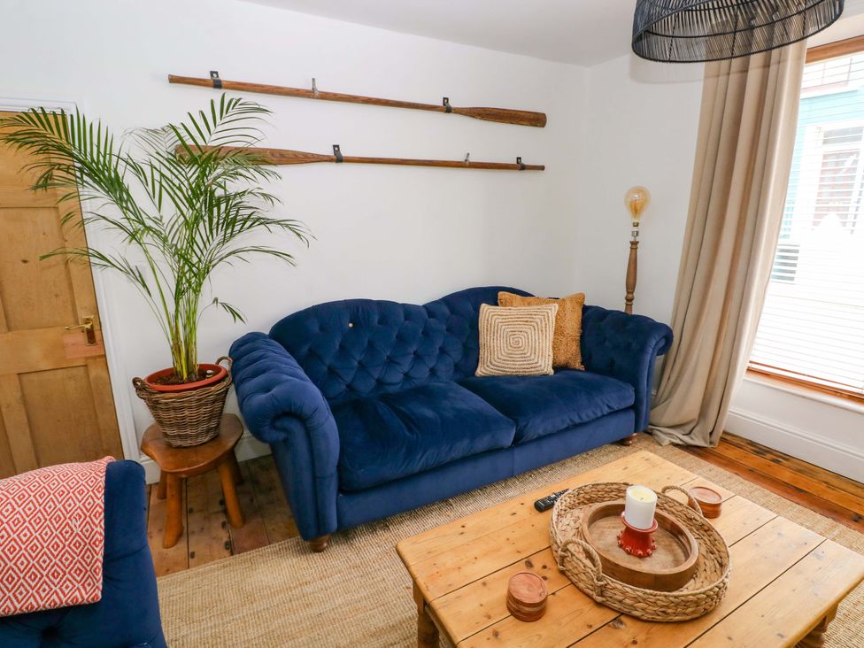 A living room with a blue sofa and wooden table at 18 Main Street