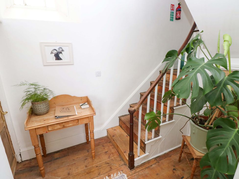 A hallway with stairs and a table at 18 Main Street