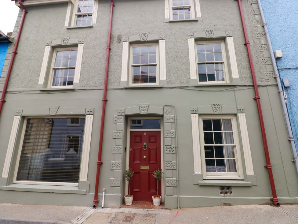 The exterior of a house with multiple windows and a red door at 18 Main Street