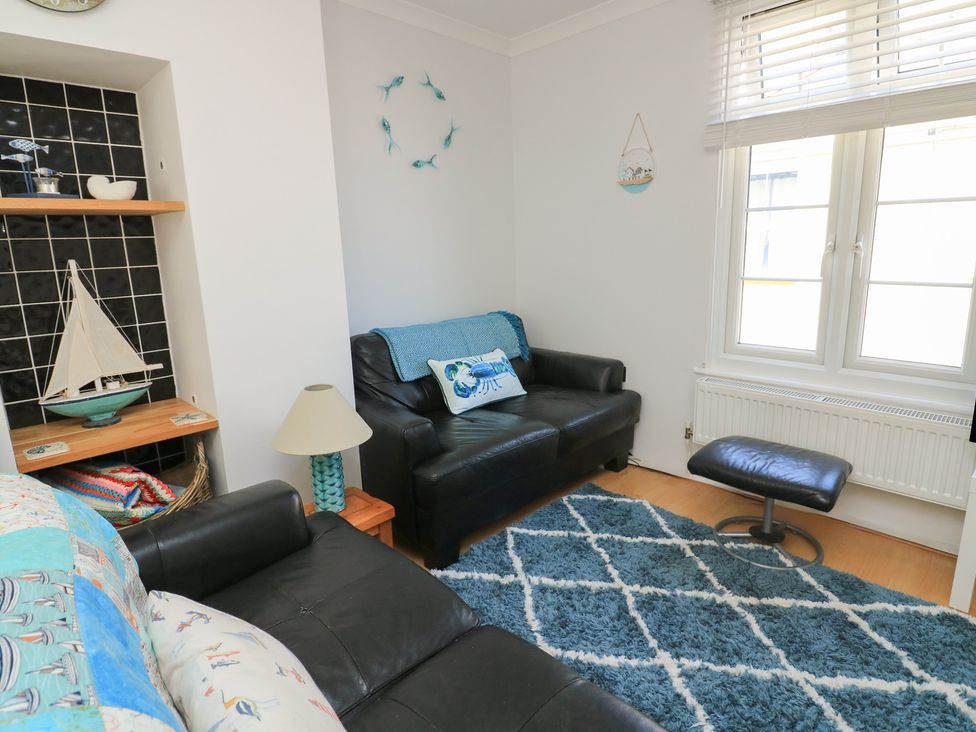 A living room with a sofa and bookshelf at The Hideaway