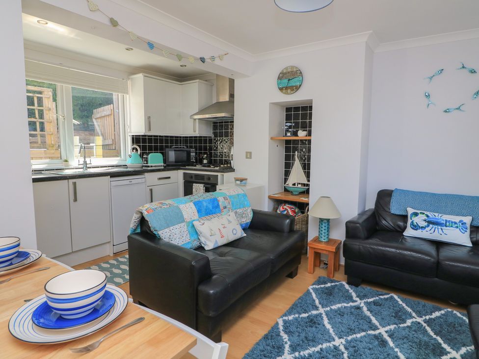 A living room with a kitchen and seating area at The Hideaway in 