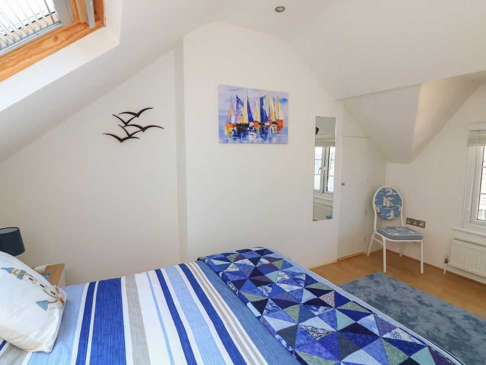 A bedroom with a bed and a chair at The Hideaway