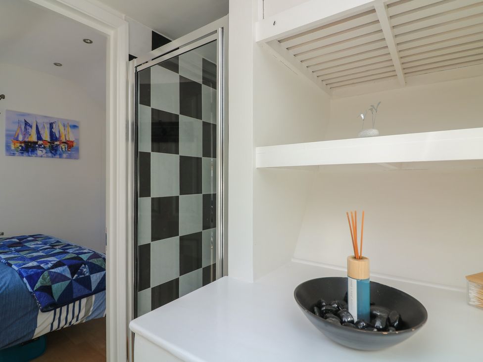 A bathroom with a shower and a decorative shelf at The Hideaway in 