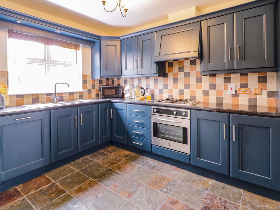 A kitchen with cabinets, stove, sink, and microwave at 7 Killybrack Glen, Omagh