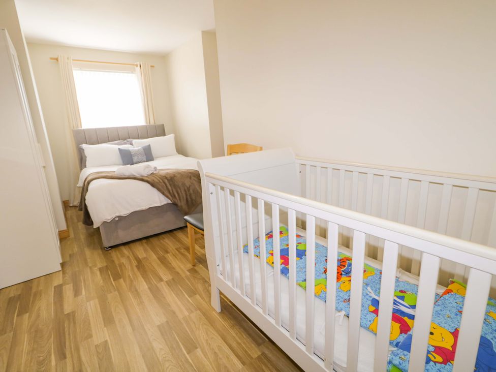 A bedroom with a bed and a crib at 7 Killybrack Glen, Omagh