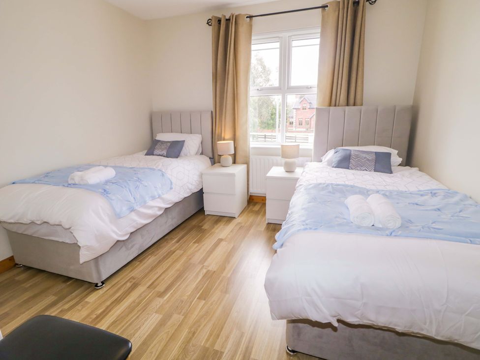 A bedroom with two beds and a nightstand at 7 Killybrack Glen in Omagh