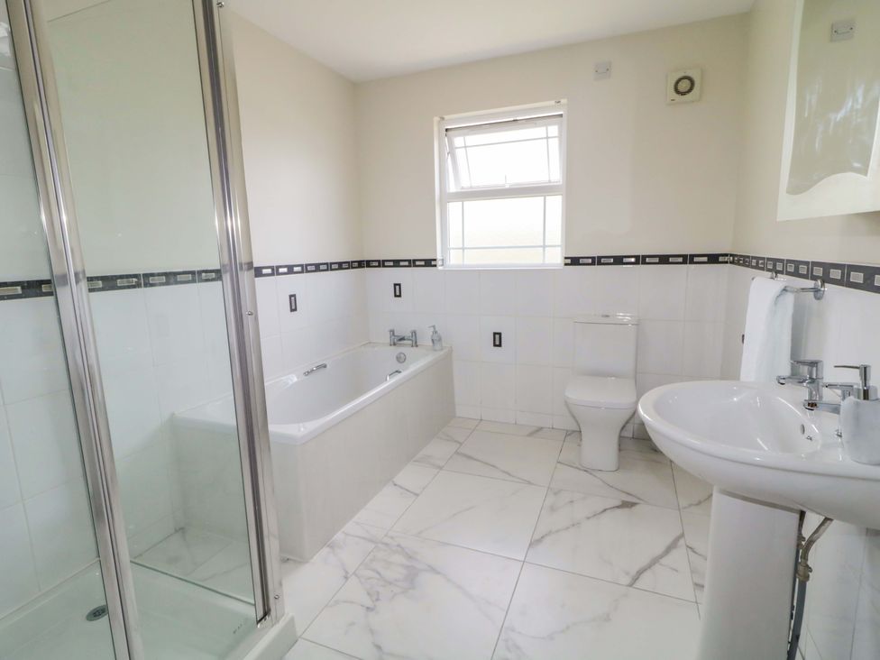 A bathroom with a bathtub, shower, sink, and toilet at 7 Killybrack Glen Omagh