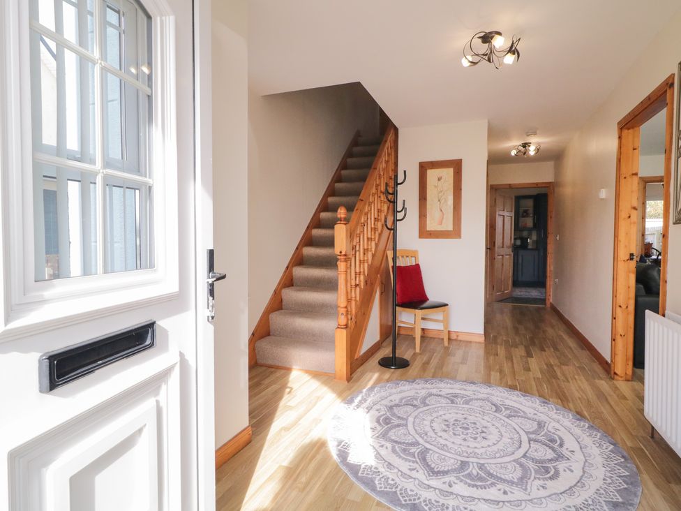 A hallway with a staircase and coat rack at The Sperrin Getaway in Omagh