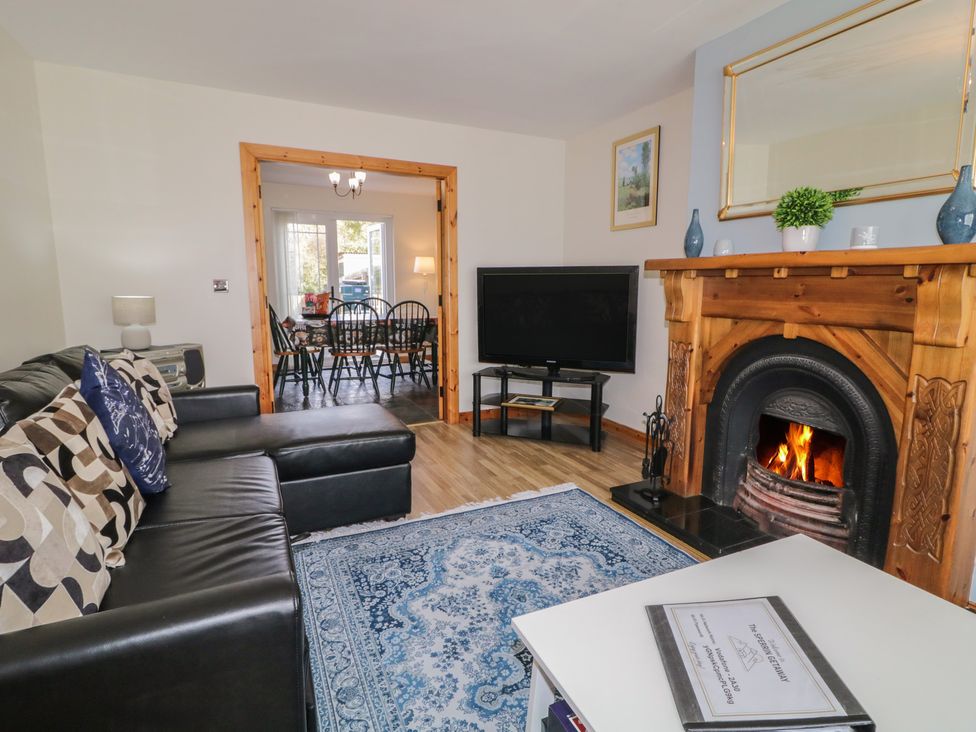 A living room with a sofa, television, and fireplace at The Sperrin Getaway in Omagh