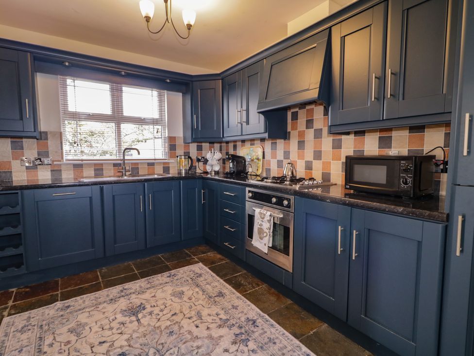 A kitchen with cabinets and appliances at The Sperrin Getaway in Omagh