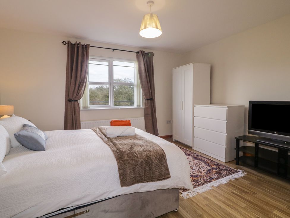 A bedroom with a bed and wardrobe at The Sperrin Getaway in Omagh
