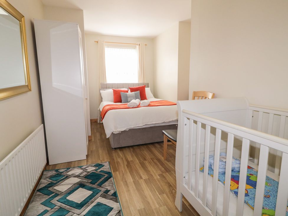 A bedroom with a bed, crib, and furniture at The Sperrin Getaway in Omagh