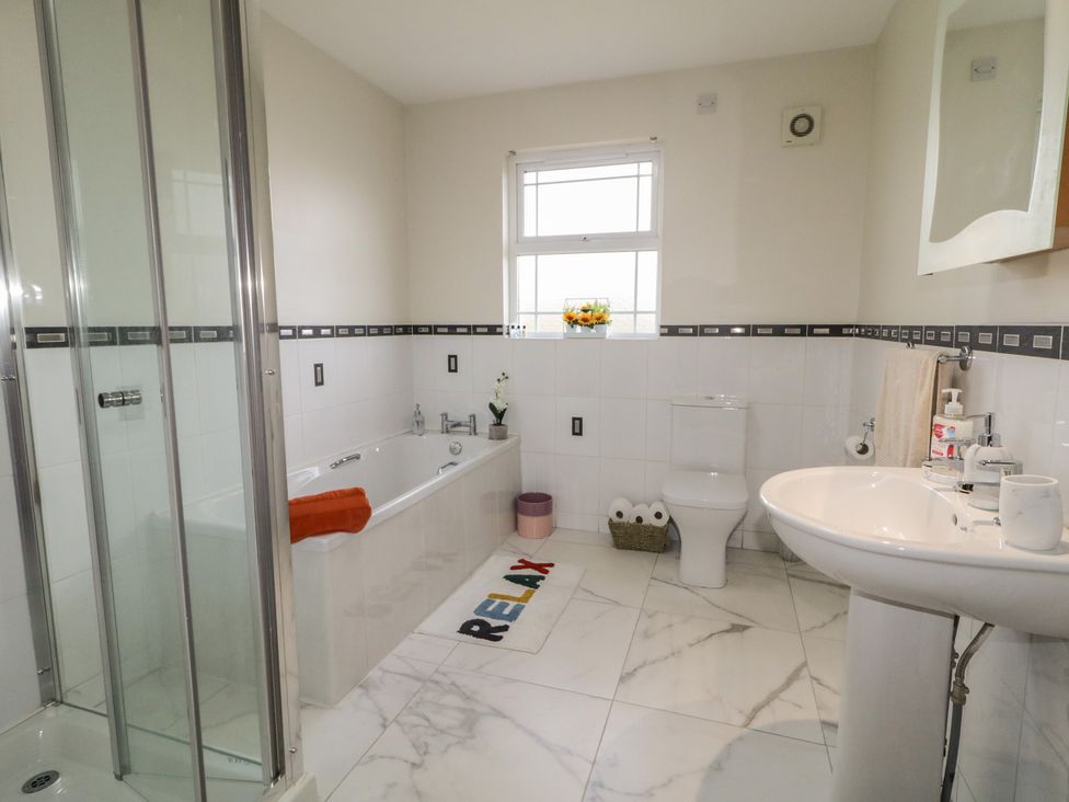 A bathroom with a shower, bathtub, sink, and toilet at The Sperrin Getaway in Omagh
