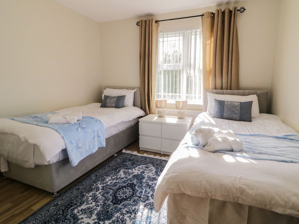 A bedroom with two beds and a dresser at The Sperrin Getaway in Omagh