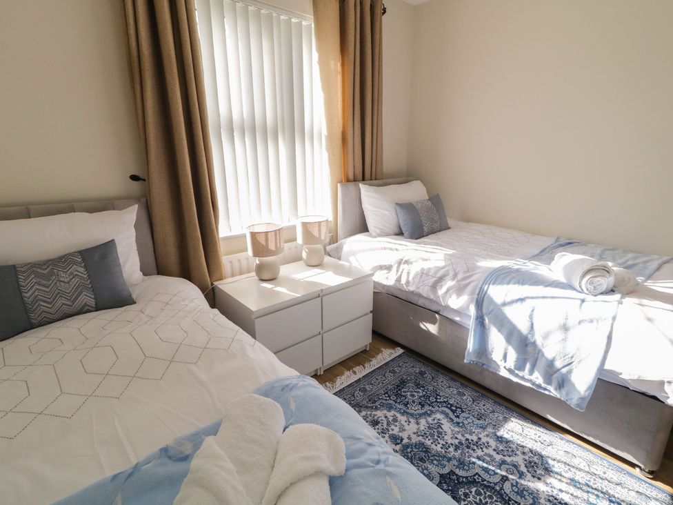 A bedroom with two beds and a nightstand at The Sperrin Getaway in Omagh