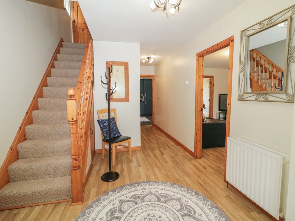 A hallway with stairs and a coat rack at The Sperrin Getaway in Omagh