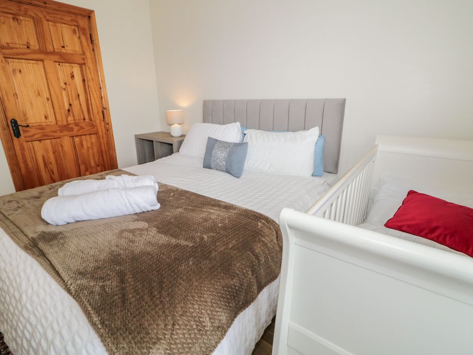A bedroom featuring a bed and crib at The Sperrin Getaway in Omagh