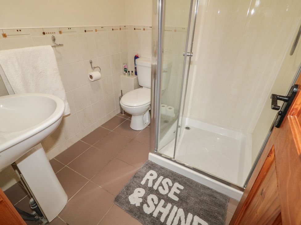 A bathroom with a sink, a toilet, and a shower at The Sperrin Getaway in Omagh
