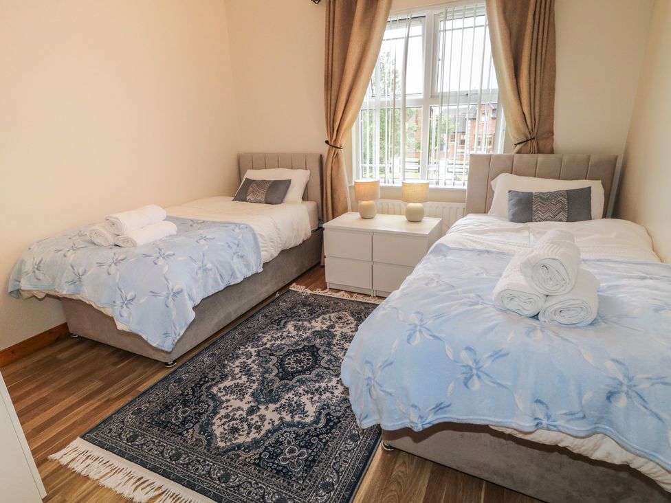 A bedroom with two beds and a bedside table at The Sperrin Getaway in Omagh