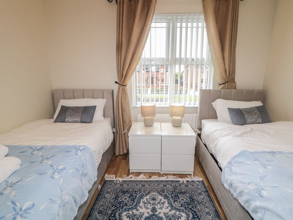 A bedroom with two single beds and a nightstand at The Sperrin Getaway in Omagh