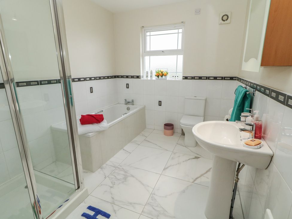 A bathroom with a shower, bathtub, toilet, and sink at The Sperrin Getaway in Omagh