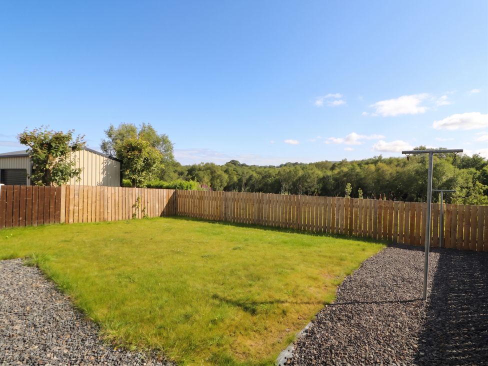 A garden with grass, fence, and shed at The Sperrin Getaway in Omagh