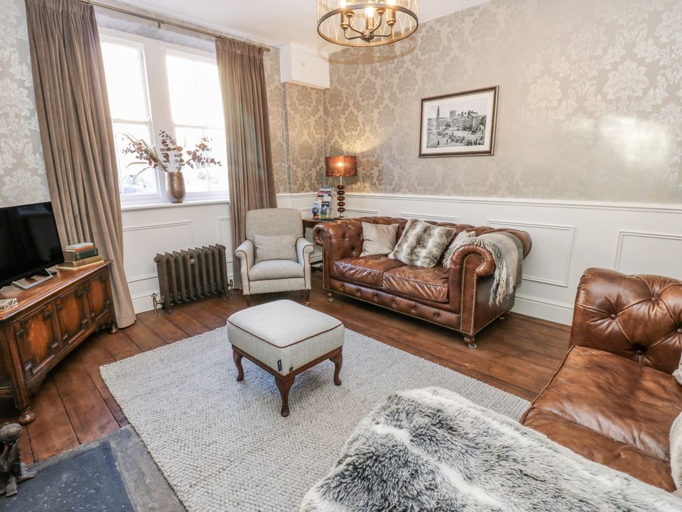 A living room with a sofa, armchair and footstool at 26 Frenchgate in Richmond