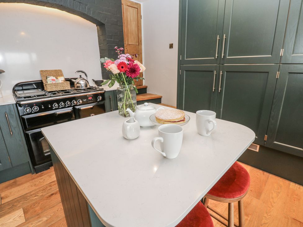 A kitchen with mugs and cake on the island at 26 Frenchgate in Richmond