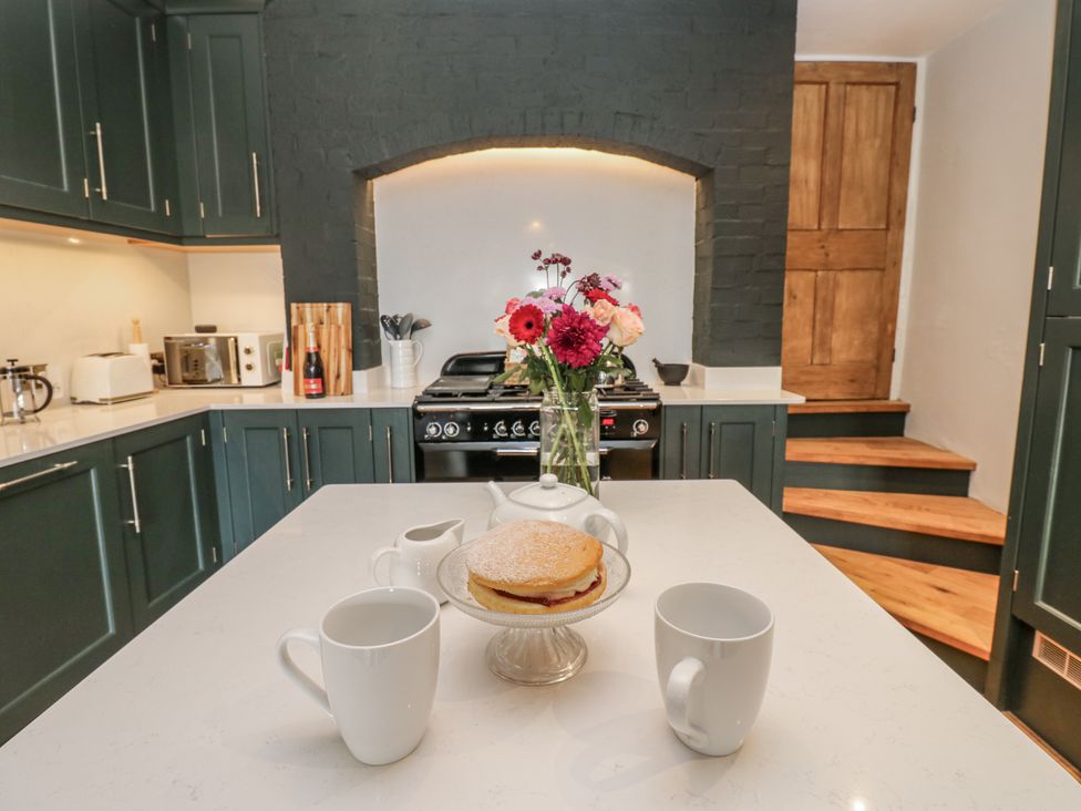 A kitchen with a stove and a cake on the counter at 26 Frenchgate in Richmond
