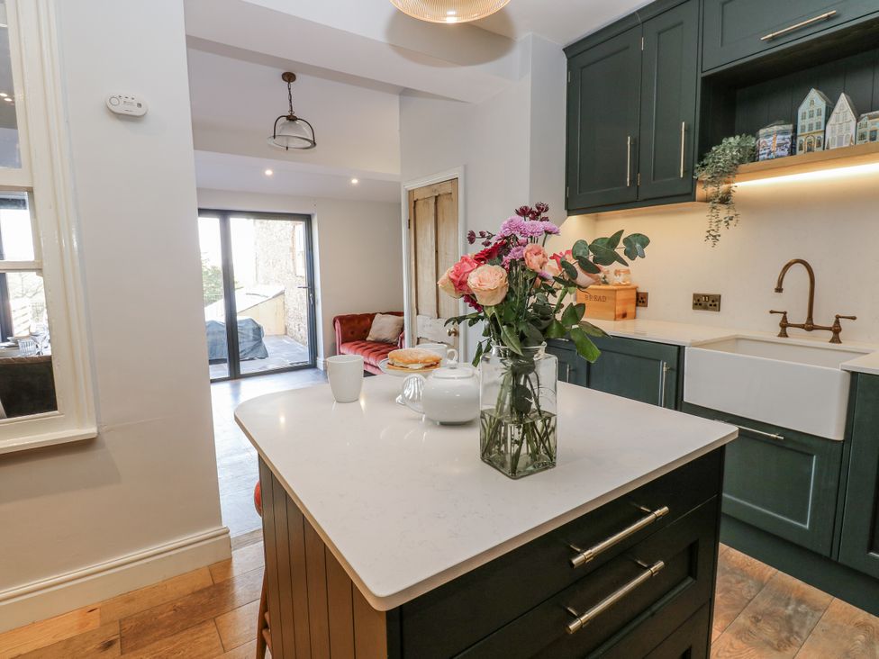 A kitchen with a sink and flowers on the island at 26 Frenchgate in Richmond