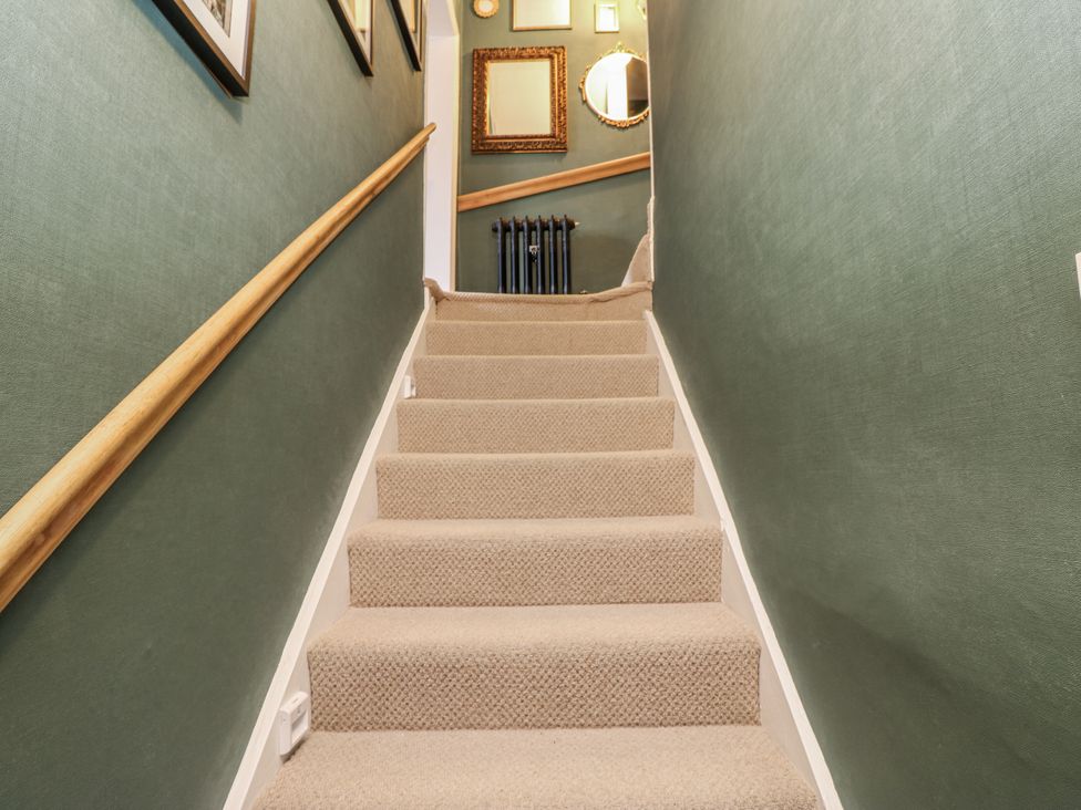 A staircase with carpet and a wall with pictures at 26 Frenchgate in Richmond