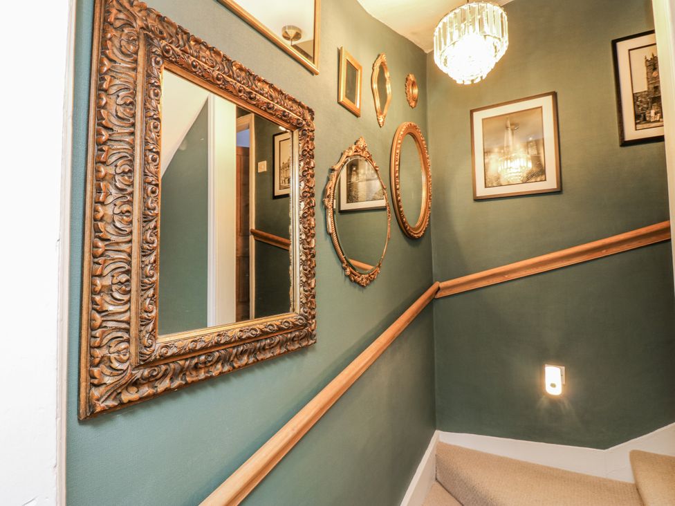 A staircase with mirrors and framed pictures at 26 Frenchgate in Richmond