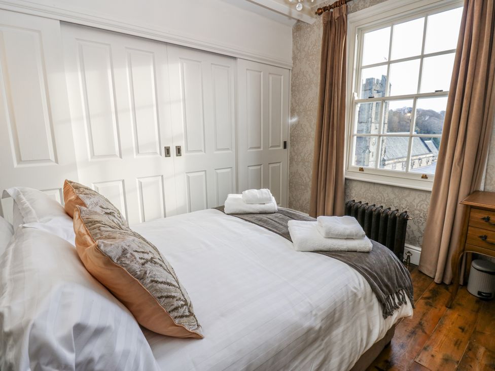 A bedroom with a bed and wardrobe at 26 Frenchgate in Richmond