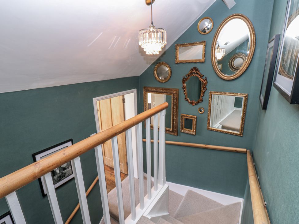 A staircase with wall mirrors and light fixture at 26 Frenchgate in Richmond