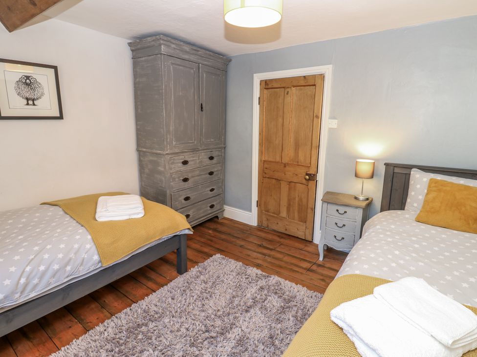 A bedroom with two beds and a wardrobe at 26 Frenchgate in Richmond