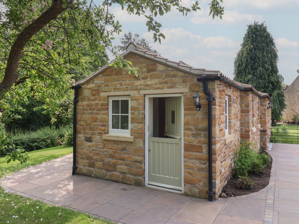 An exterior view of a stone building with a door and window at Apple Tree Cottage in York