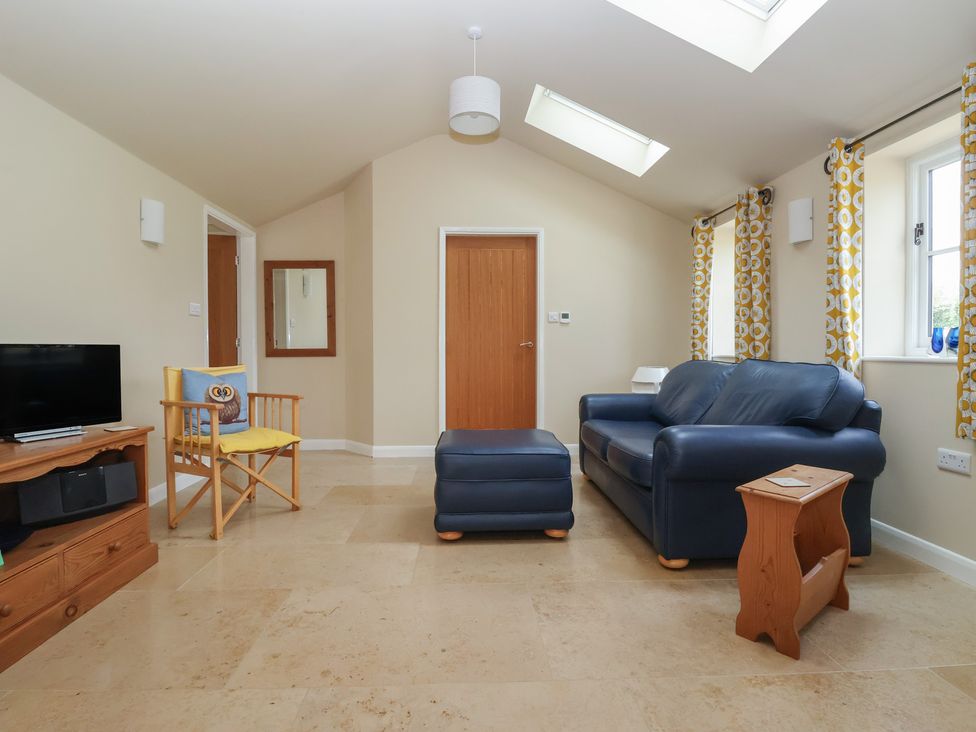 A living room with a television and sofa at Apple Tree Cottage in York