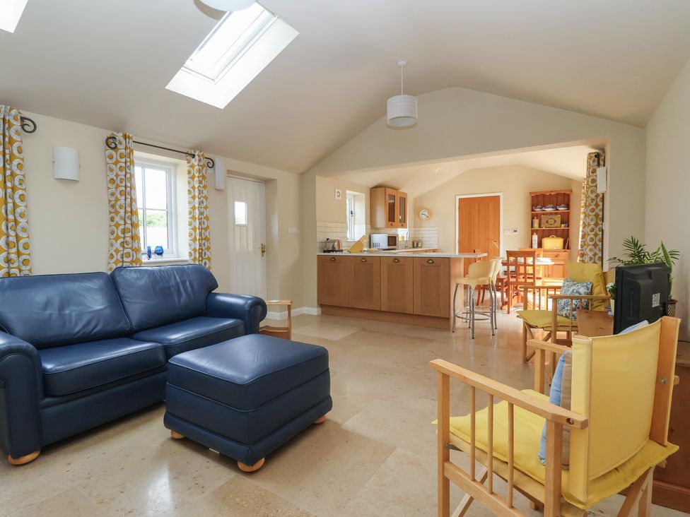 A living room with a sofa and ottoman at Apple Tree Cottage in York
