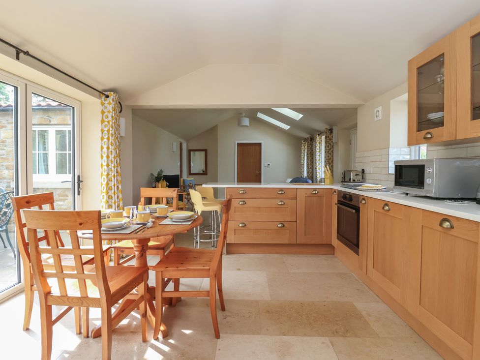 A kitchen with a dining area and appliances at Apple Tree Cottage in York