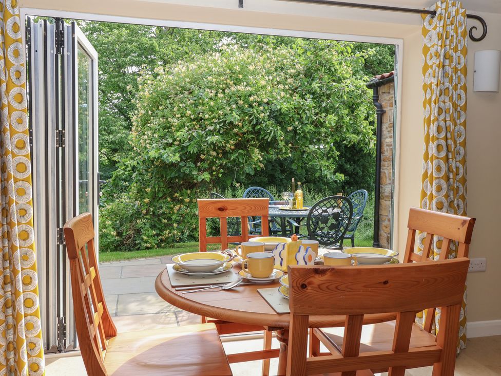 A dining room with a table and chairs at Apple Tree Cottage in York