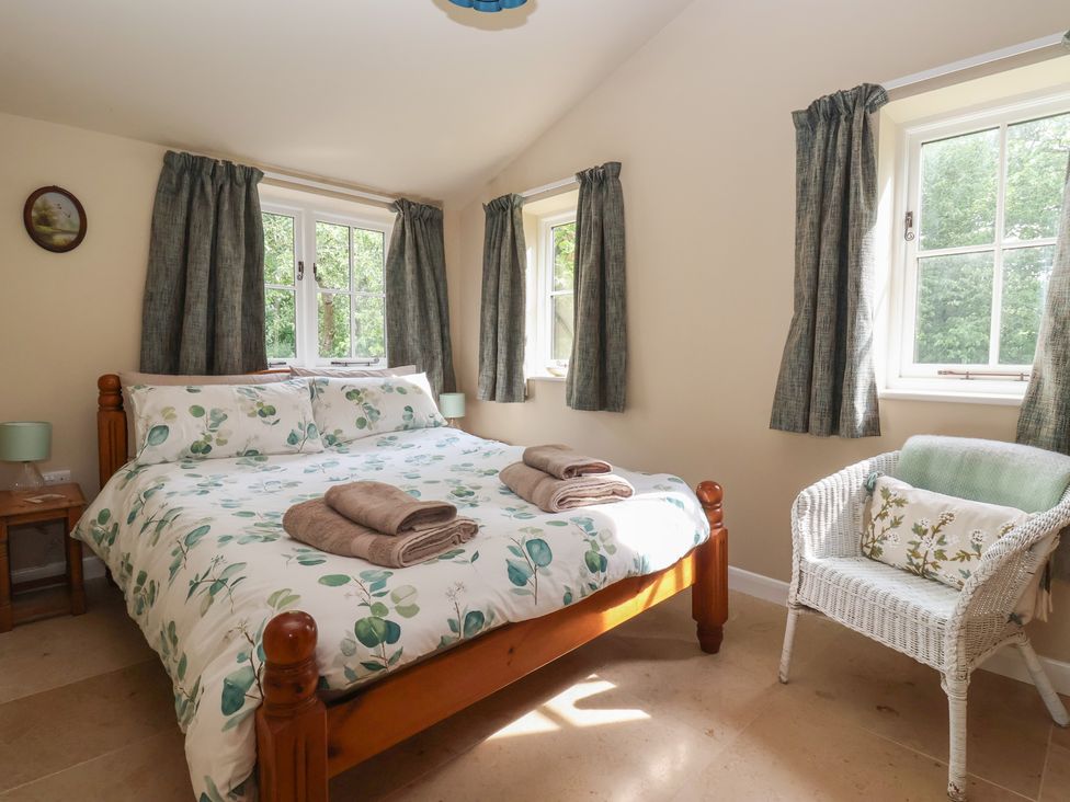 A bedroom with a bed and a chair at Apple Tree Cottage in York