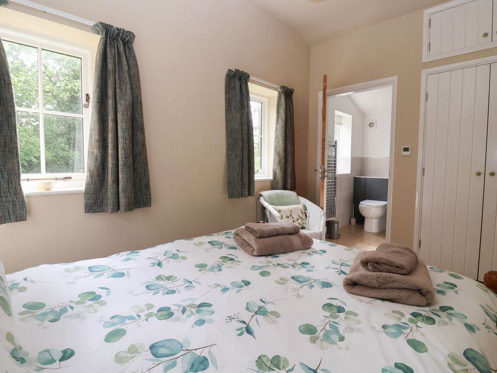 A bedroom with a bed and towels on the bed at Apple Tree Cottage in York