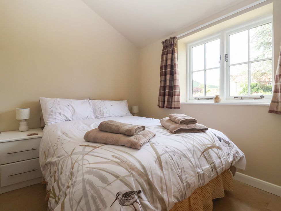 A bedroom with a bed and bedside table at Apple Tree Cottage in York