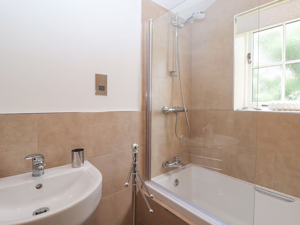 A bathroom with a bathtub and washbasin at Apple Tree Cottage in York