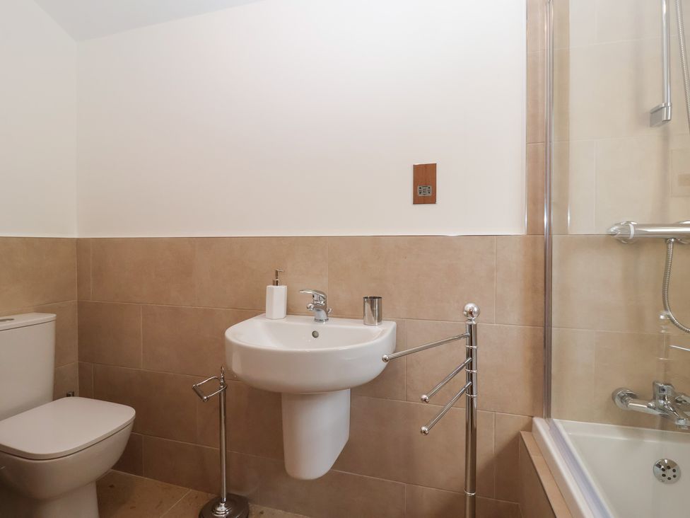 A bathroom featuring a toilet, sink, towel rail, and bathtub at Apple Tree Cottage in York