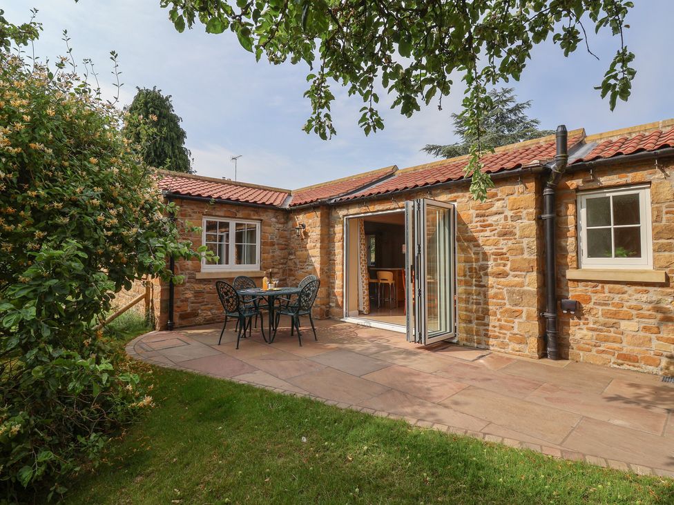 An outdoor area with a table and chairs at Apple Tree Cottage in York