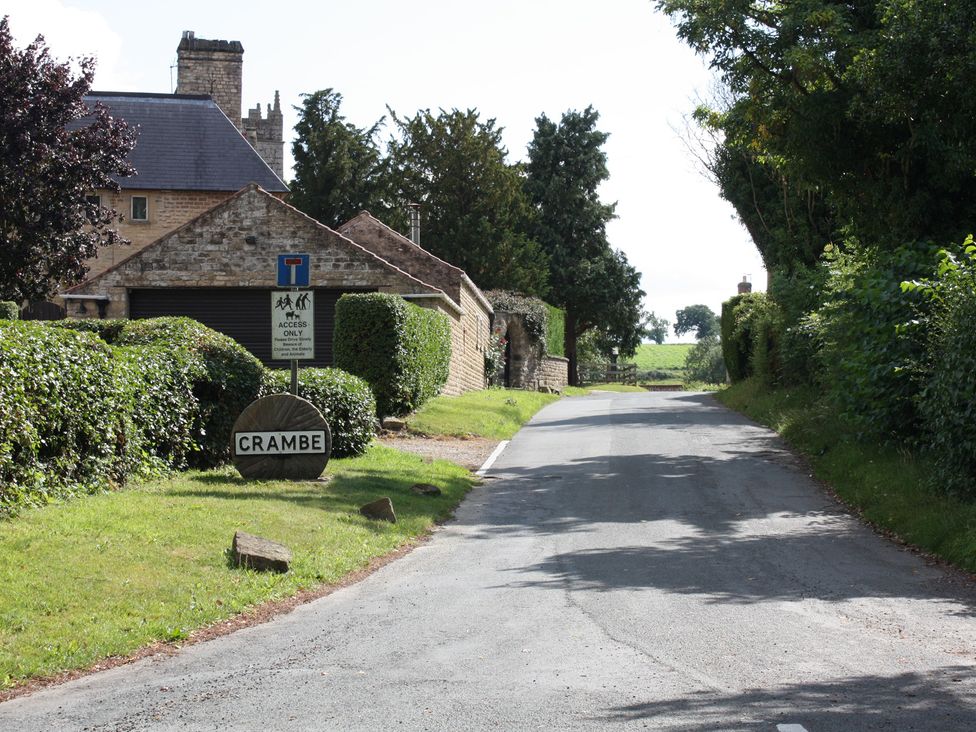 A road with a sign and hedges at Apple Tree Cottage in York