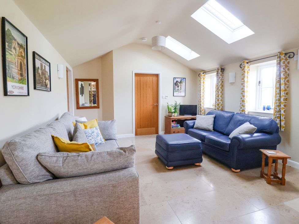 A living room with sofas and a television at Apple Tree Cottage in York