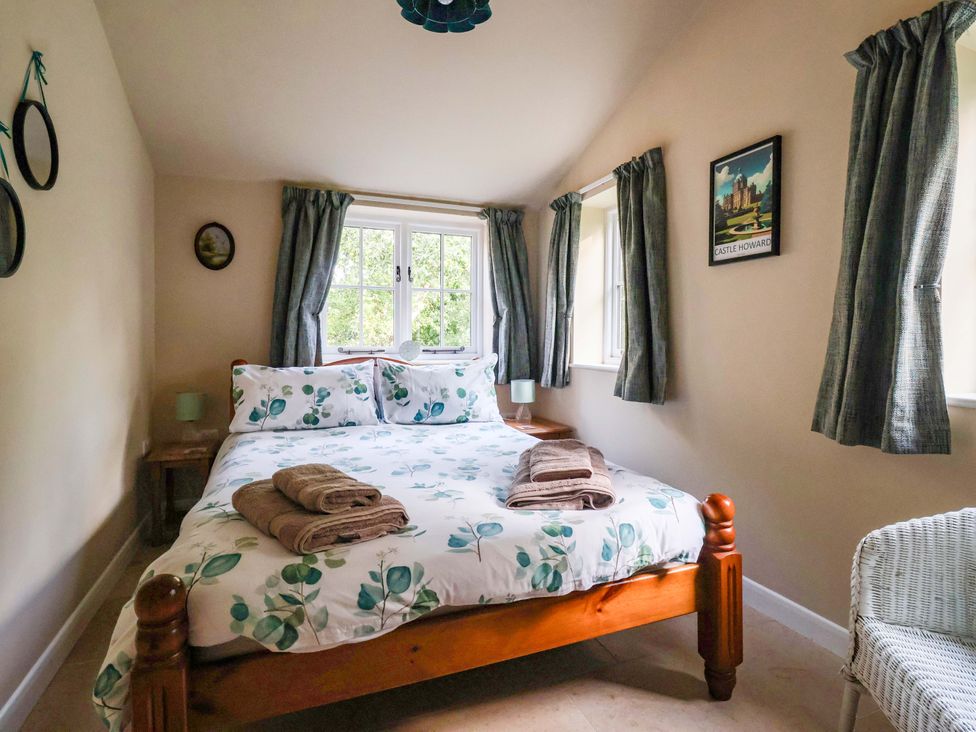 A bedroom with a bed and towels at Apple Tree Cottage York